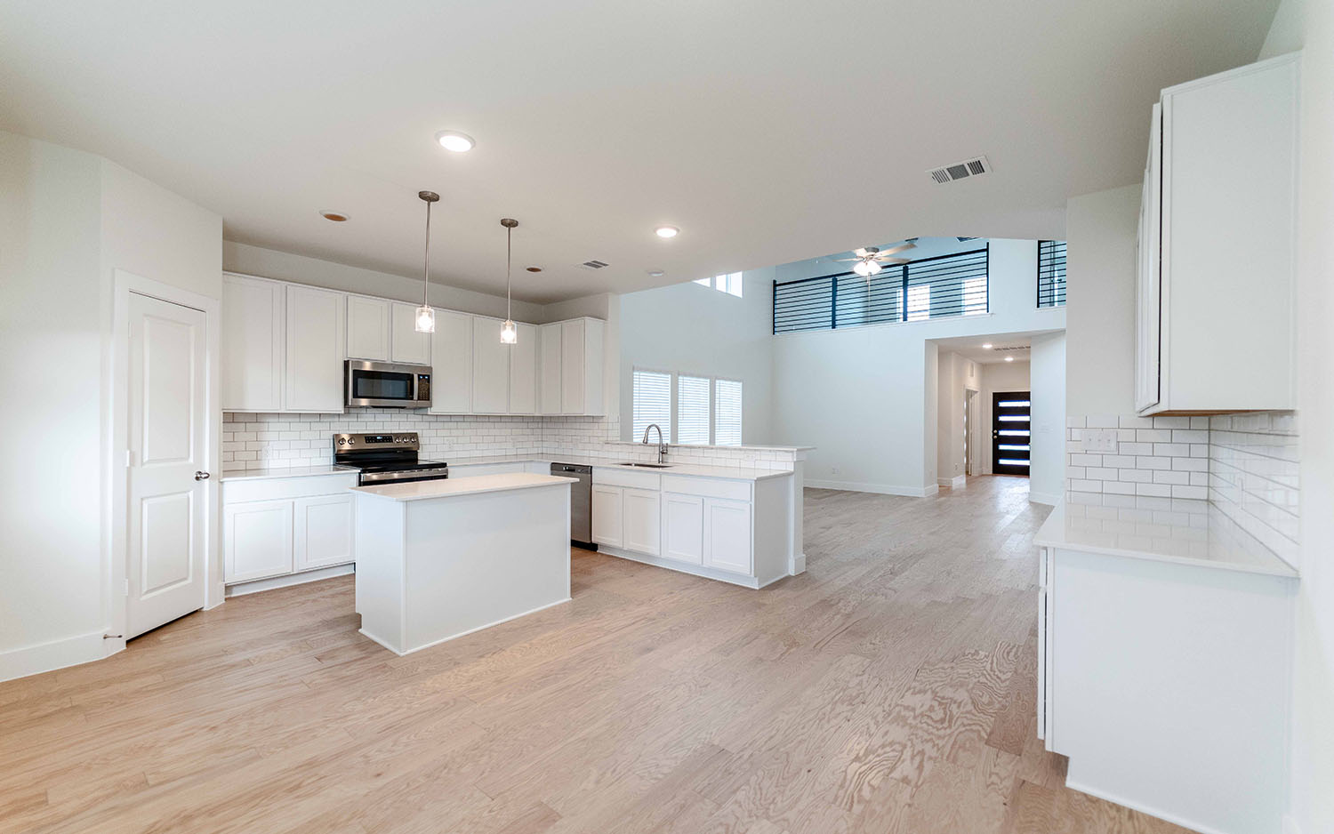 104 Old Silver Drive Jarrell, TX 76537 - Photo 9 of 19 Kitchen featuring decorative backsplash, white cabinetry, light wood-type flooring, appliances with stainless steel finishes, and recessed lighting