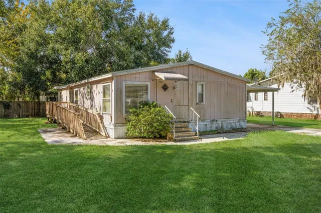 a view of a house with backyard and a patio