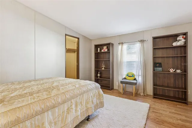 a bedroom with a bed and wooden floor