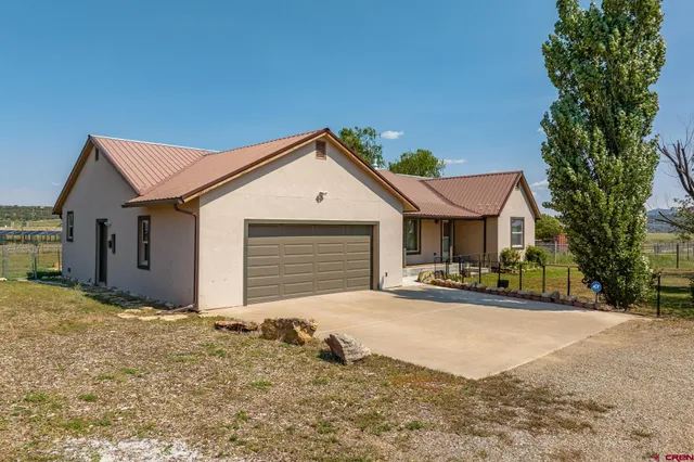 a view of a house with a yard and garage