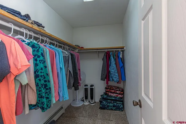 a view of walk in closet with clothes and shoes