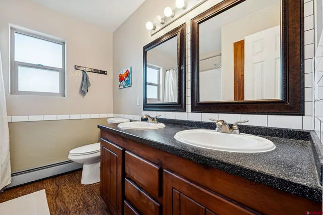 a bathroom with a granite countertop sink a large mirror and a toilet