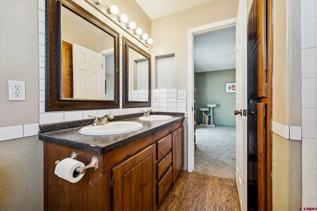 a en suite bathroom with a granite countertop sink and a mirror