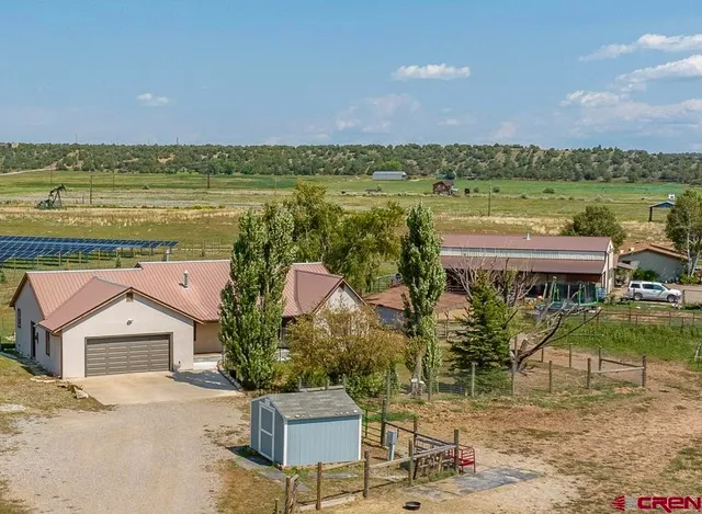 an aerial view of a house with a garden and lake view