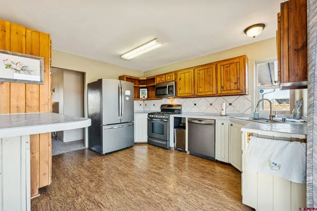 a kitchen with stainless steel appliances a stove a sink and a refrigerator
