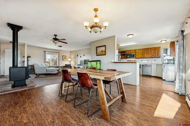 a dining room with wooden floor a chandelier a wooden table and chairs