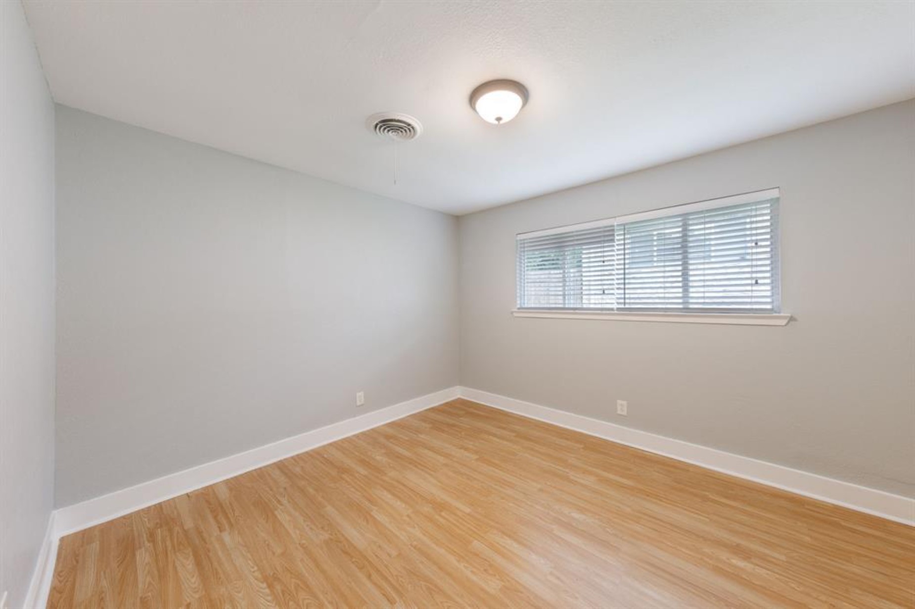 1423 Braes Ridge Drive, Unit B Austin, TX 78723 - Photo 11 of 13 an empty room with wooden floor and windows