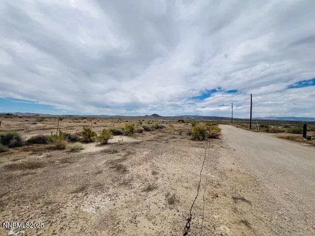 a view of a dry yard with wooden fence