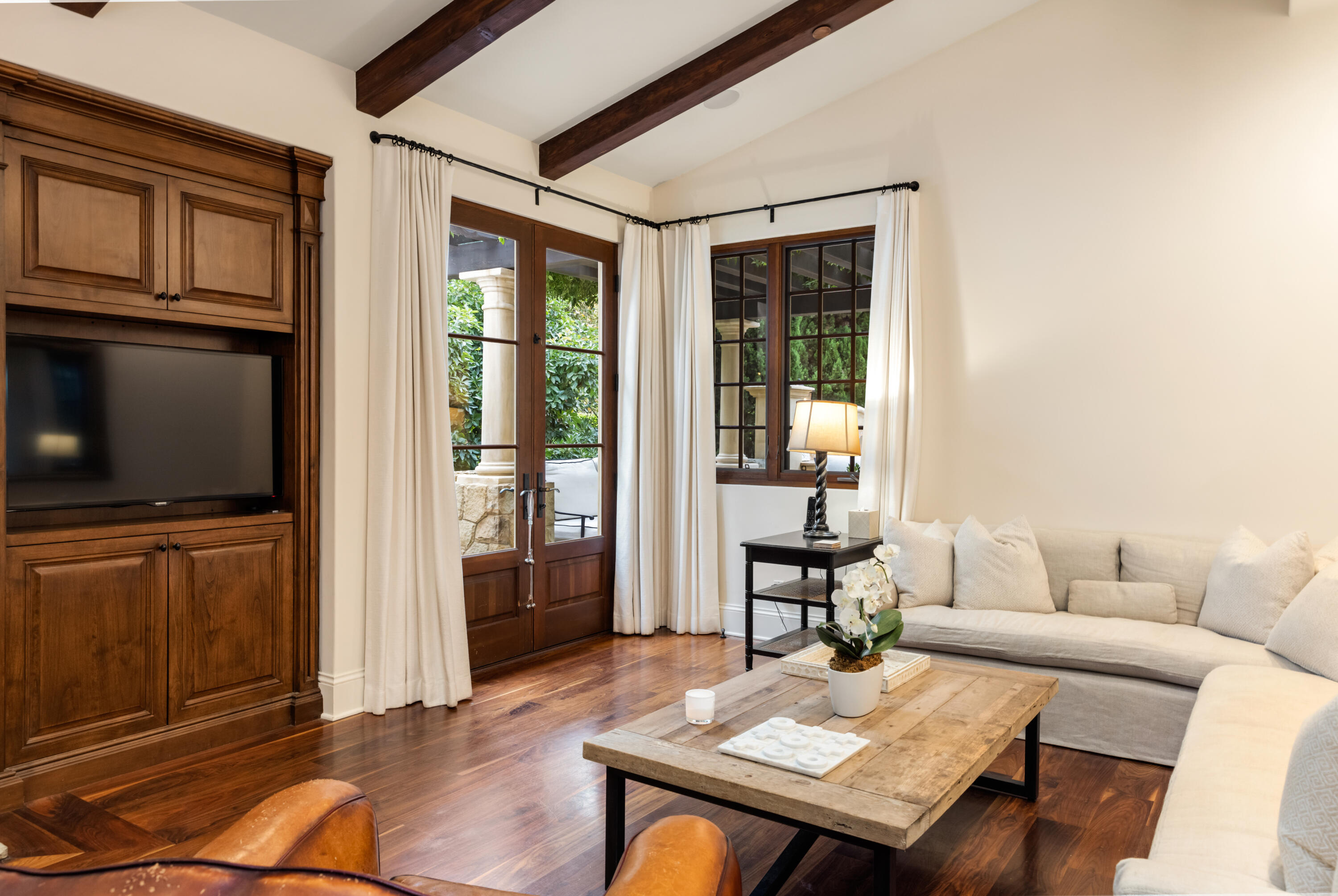 2035 Creekside Road Montecito, CA 93108 - Photo 28 of 60 a living room with furniture a flat screen tv and floor to ceiling window