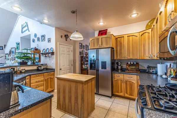 a kitchen with kitchen island granite countertop a sink a counter top space and cabinets