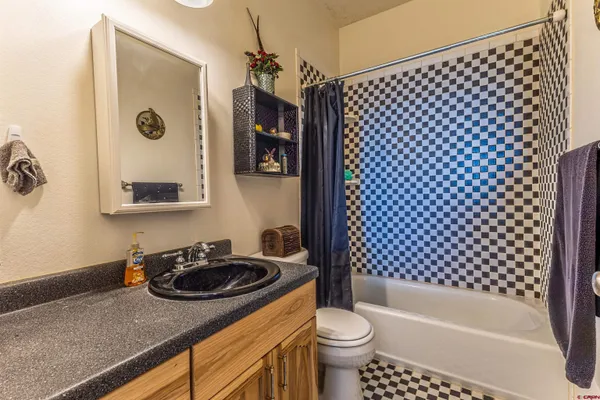 a bedroom with a bed and a dresser next to a window