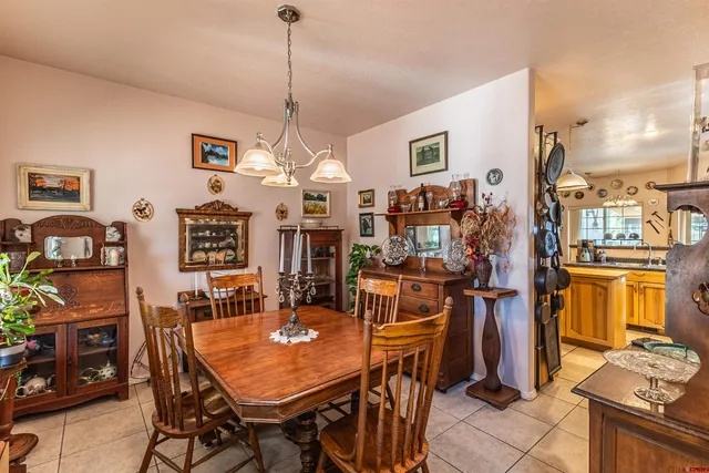 a dining room filled chandelier and wooden floor