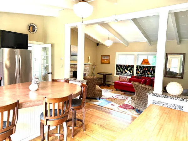 a view of a dining room with furniture a rug and wooden floor