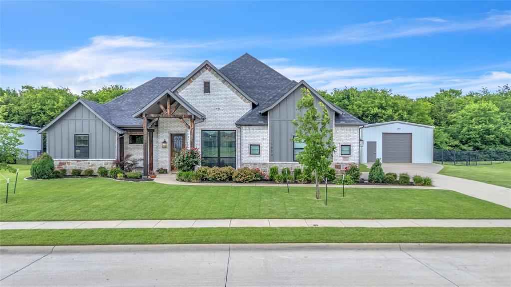 1014 Rennard Street Caddo Mills, TX 75135 - Photo 2 of 39 Modern farmhouse style exterior featuring brick, board & batten siding, and a stone exterior. Also shown is the covered front porch and elevated landscaping.