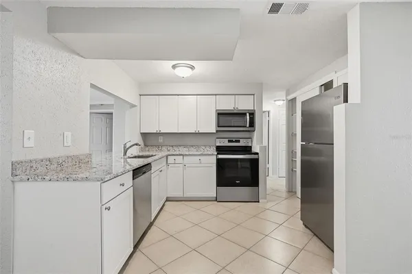 a kitchen with a refrigerator sink and cabinets