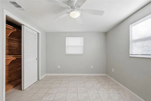 an empty room with windows and closet