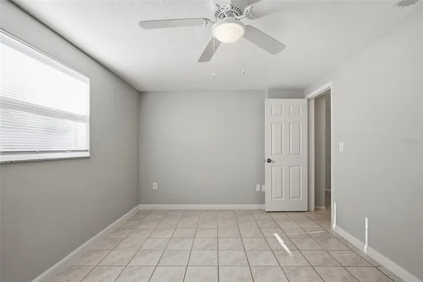 en empty room with windows and fan
