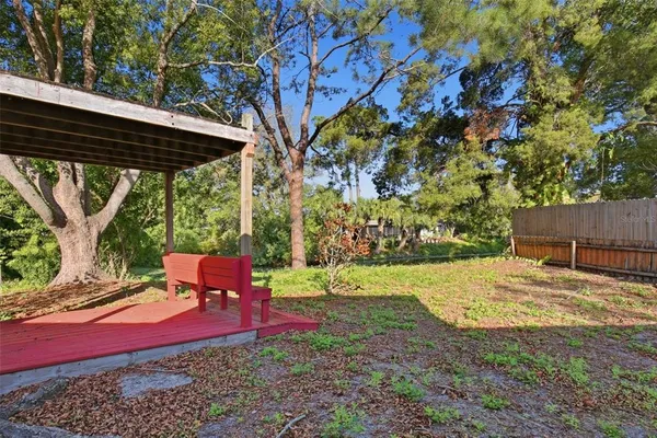 a backyard of a house with table and chairs under an umbrella