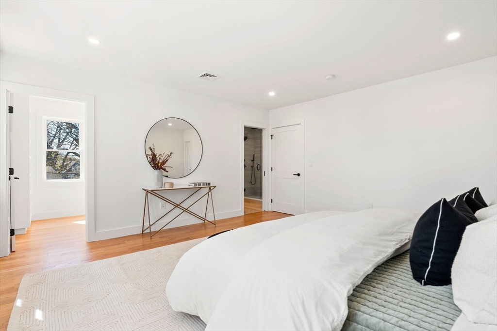 4 Wilbur Street Woburn, MA 01801 - Photo 15 of 39 a bedroom with a bed a mirror and paintings on the wall