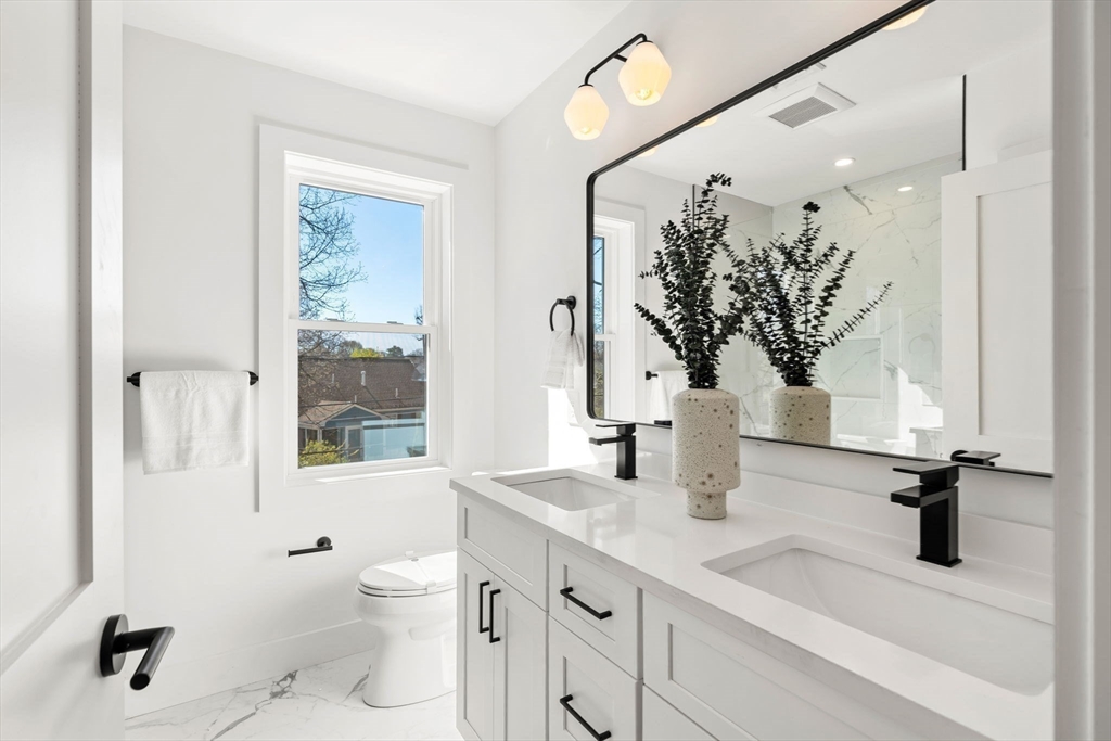 4 Wilbur Street Woburn, MA 01801 - Photo 23 of 39 a bathroom with a granite countertop sink a toilet and a mirror