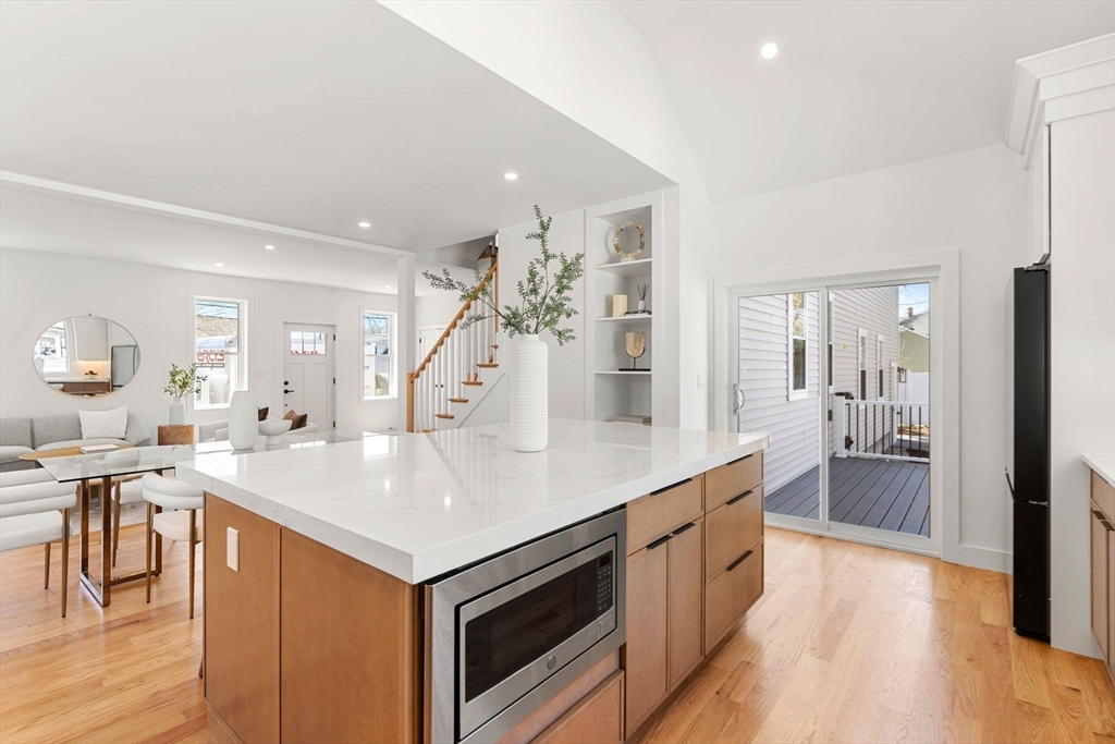 4 Wilbur Street Woburn, MA 01801 - Photo 7 of 39 a large white kitchen with a center island and stainless steel appliances