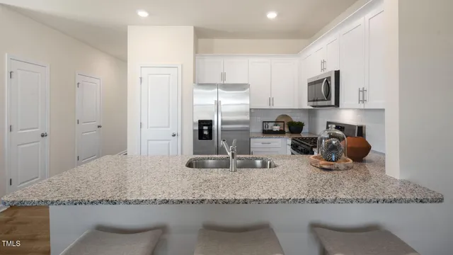 a kitchen with stainless steel appliances granite countertop a sink refrigerator and microwave