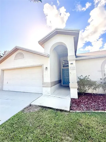 a front view of a house with a garden and plants