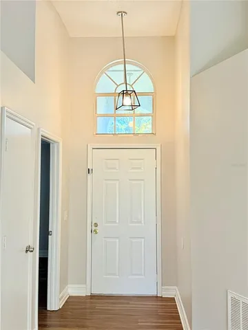 a view of a hallway with a chandelier fan