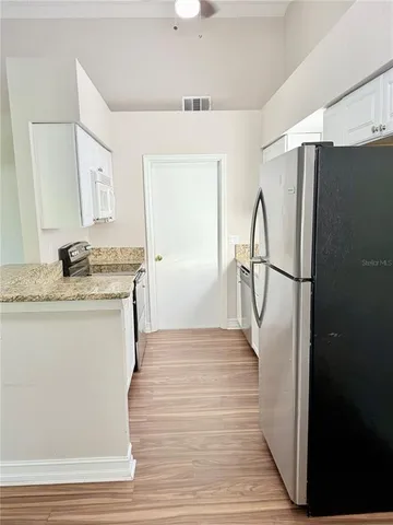 a kitchen with granite countertop a refrigerator and a sink