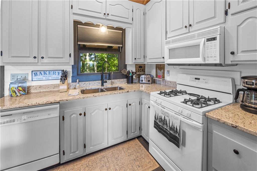 832 Scenic Mountain View Road Blue Ridge, GA 30513 - Photo 10 of 56 a kitchen with white cabinets and appliances