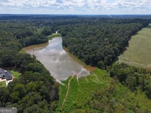 an aerial view of a house with a yard and lake view