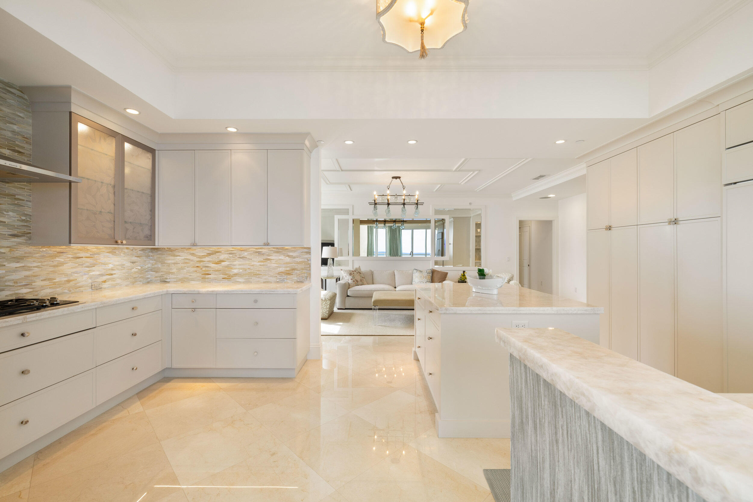 5050 North Ocean Drive, Unit 1502 Singer Island, FL 33404 - Photo 11 of 56 a large white kitchen with a stove a sink a dishwasher and cabinets with wooden floor