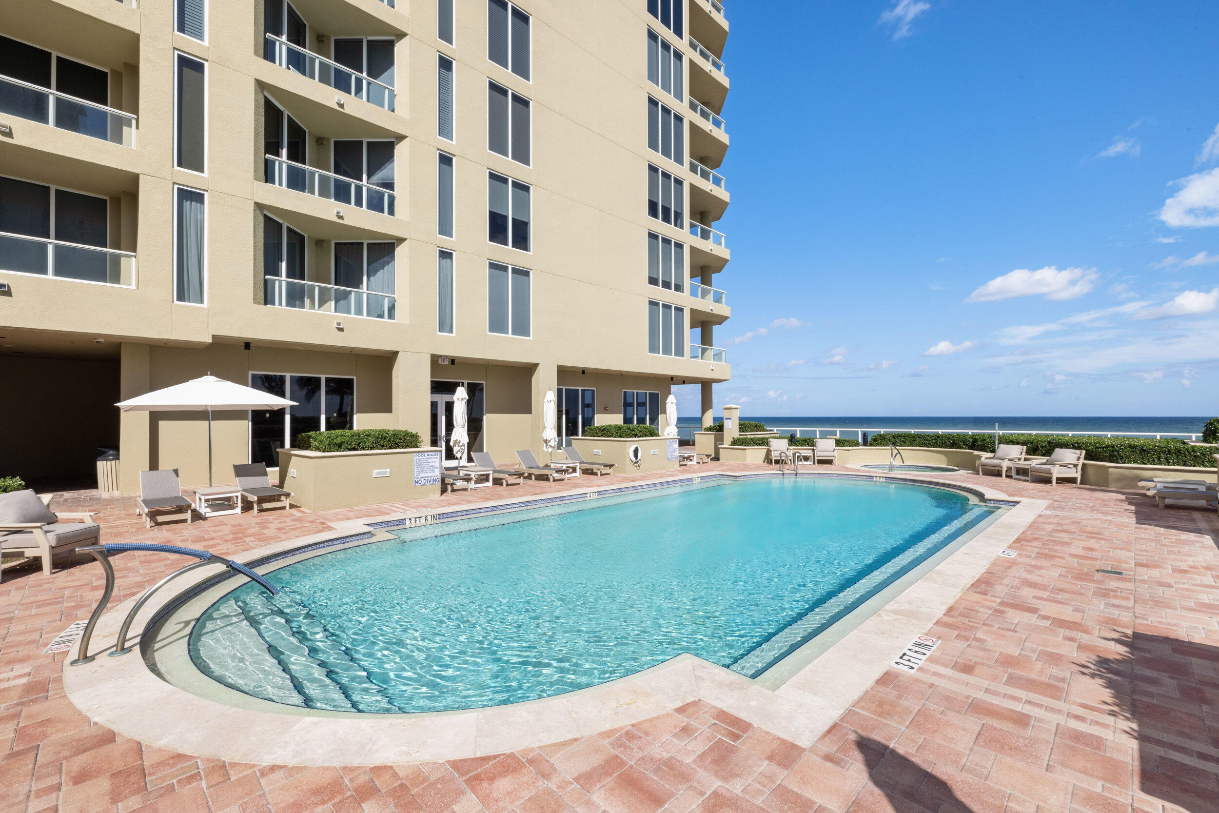 5050 North Ocean Drive, Unit 1502 Singer Island, FL 33404 - Photo 42 of 56 a view of a swimming pool with a lounge chairs