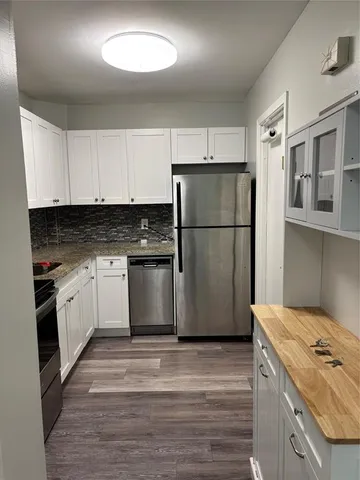 a kitchen with a refrigerator stove and white cabinets