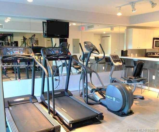 2740 Southwest 28th Terrace, Unit 507 Miami, FL 33133 - Photo 17 of 22 a room with gym equipment and a flat screen tv