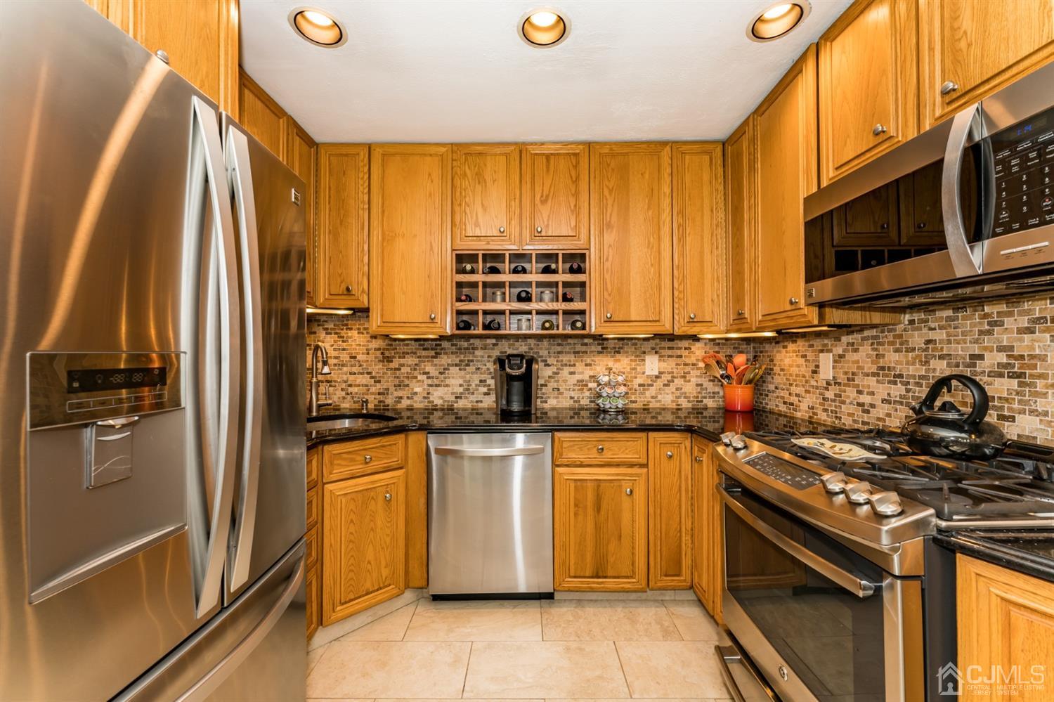 41 Trafalgar Drive Colonia, NJ 07067 - Photo 13 of 40 a kitchen with stainless steel appliances granite countertop a stove a sink and a microwave