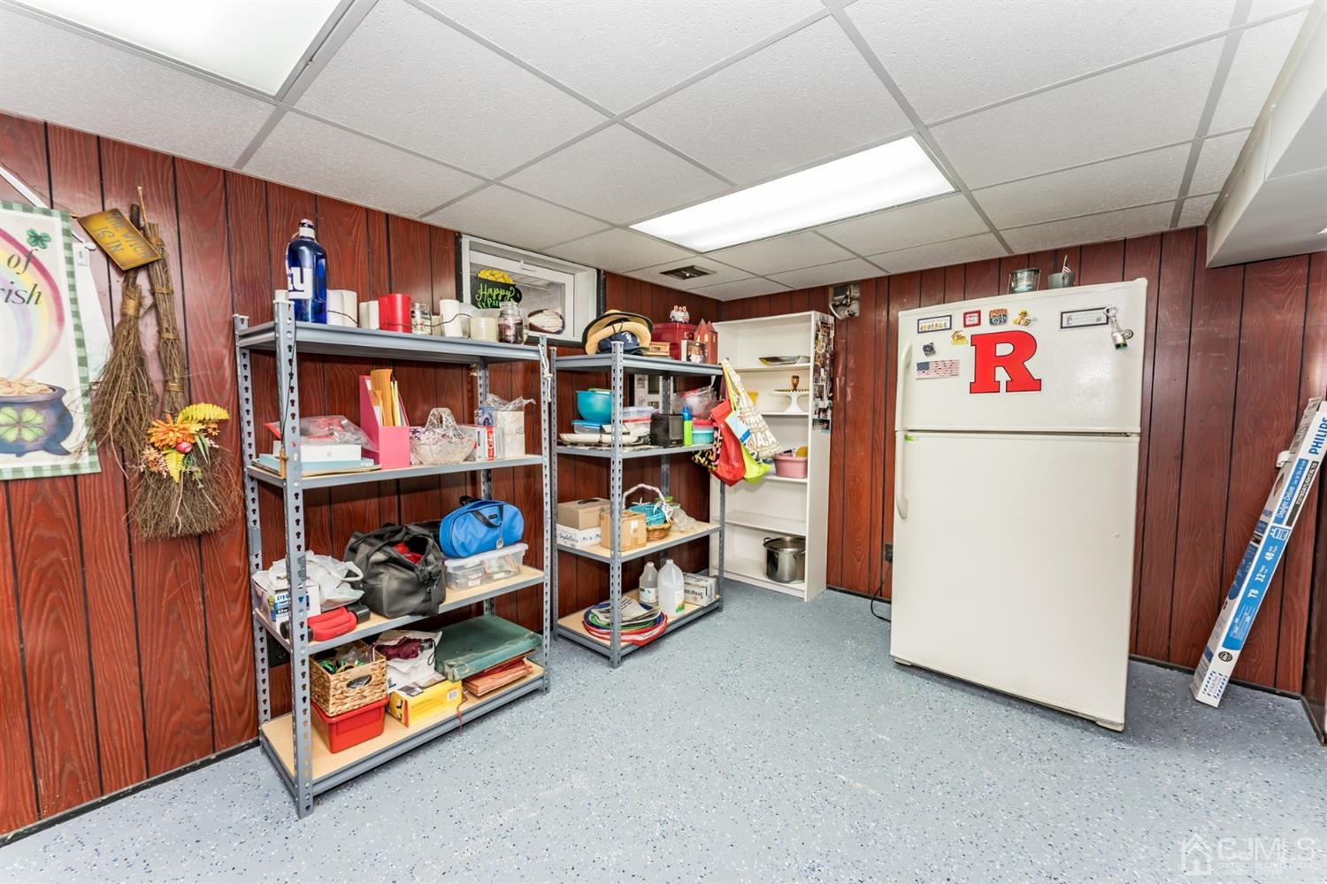 41 Trafalgar Drive Colonia, NJ 07067 - Photo 30 of 40 a utility room with fridge dryer and book shelf