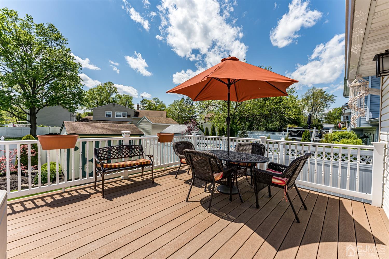 41 Trafalgar Drive Colonia, NJ 07067 - Photo 33 of 40 a view of a roof deck with table and chairs under an umbrella with wooden floor
