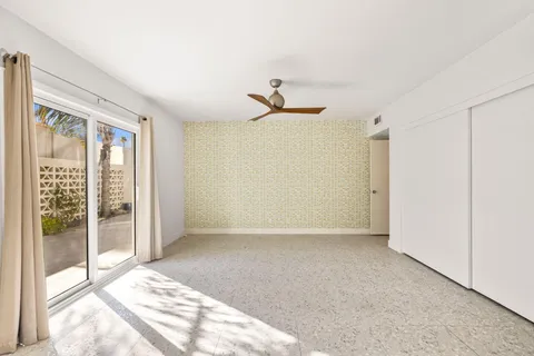a living room with couches coffee table and paintings on the wall