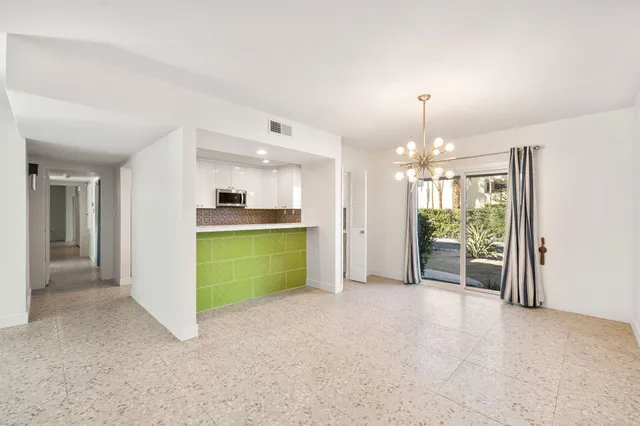 a view of a big room with windows and chandelier