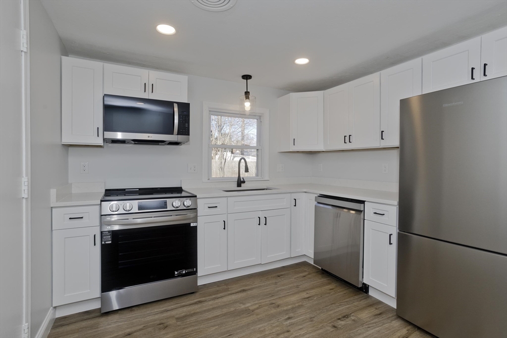 118 Keddy Street Springfield, MA 01109 - Photo 3 of 19 a kitchen with white cabinets and stainless steel appliances
