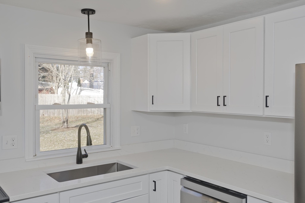 118 Keddy Street Springfield, MA 01109 - Photo 4 of 19 a kitchen with a white cabinets and a window