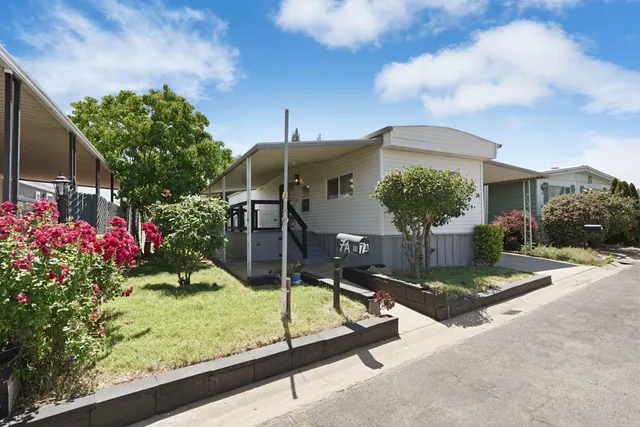a front view of a house with a yard and potted plants