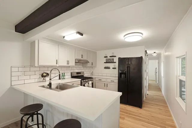 a kitchen with refrigerator and chairs