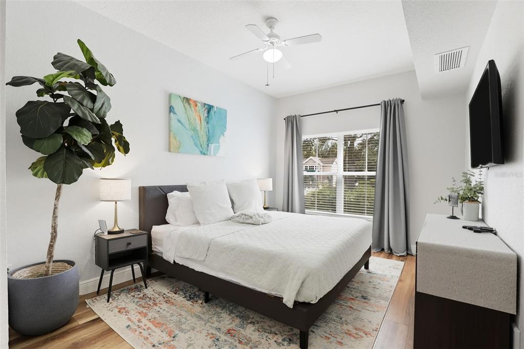 2606 Lodi Circle, Unit 102 Kissimmee, FL 34746 - Photo 15 of 37 a bedroom with a bed table flowerpot and window