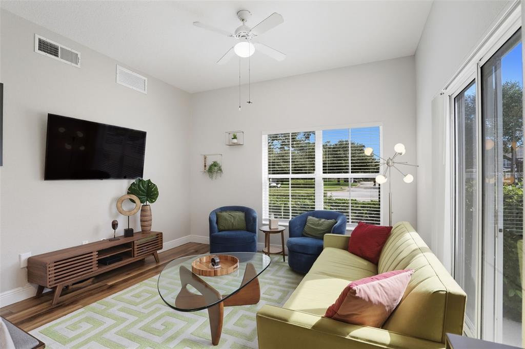 2606 Lodi Circle, Unit 102 Kissimmee, FL 34746 - Photo 5 of 37 a living room with furniture a flat screen tv and a window