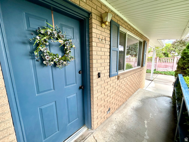 441 South 400 East Payson, UT 84651 - Photo 6 of 39 Brick exterior featuring a blue entry door, complementary shutters, and a covered concrete porch