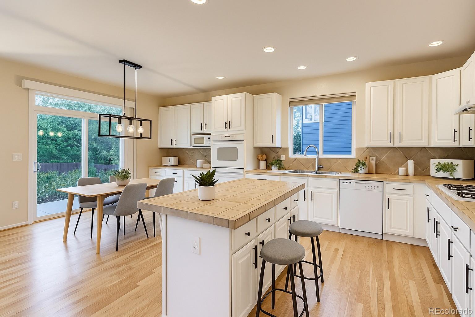 13867 Fillmore Street Thornton, CO 80602 - Photo 11 of 24 a open kitchen with stainless steel appliances granite countertop a stove top oven a sink dishwasher a dining table and chairs with wooden floor
