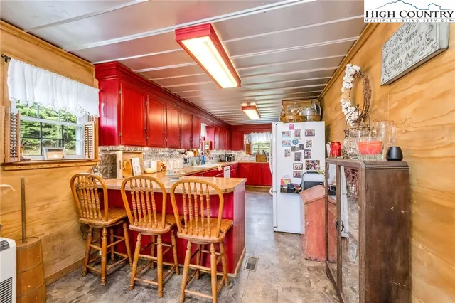 a kitchen with stainless steel appliances kitchen island granite countertop a table chairs in it and wooden floors