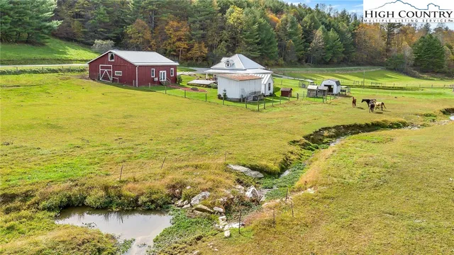 a view of a lake with a big yard and large trees